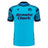 The Scotland 25/26 Sky Training Jersey by Macron features a bright blue design, dark blue geometric shoulder pattern, "Arnold Clark" sponsor text on the front, and the Scottish Rugby logo on the upper left chest.