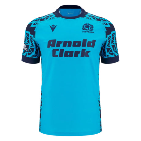The Scotland 25/26 Sky Training Jersey by Macron features a bright blue design, dark blue geometric shoulder pattern, "Arnold Clark" sponsor text on the front, and the Scottish Rugby logo on the upper left chest.