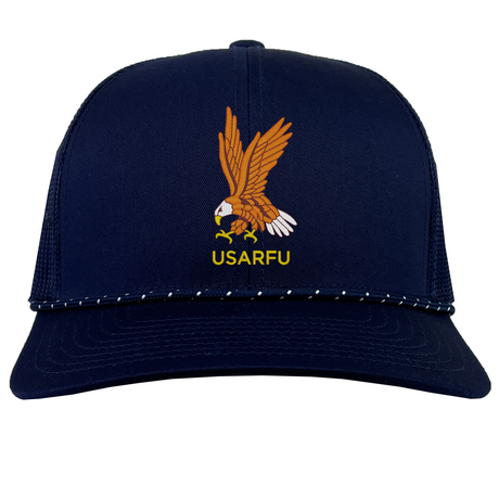 The EMB Augusta USA Rugby Heritage Braid Cap features an embroidered eagle with outstretched wings above yellow "USARFU" text on the front—a classic navy blue cap for true fans.