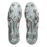 The image displays the soles of the ASICS Menace 5 FG soccer cleats in White/Speed Red, featuring multiple studs for firm ground traction and a design reminiscent of classic rugby boots.