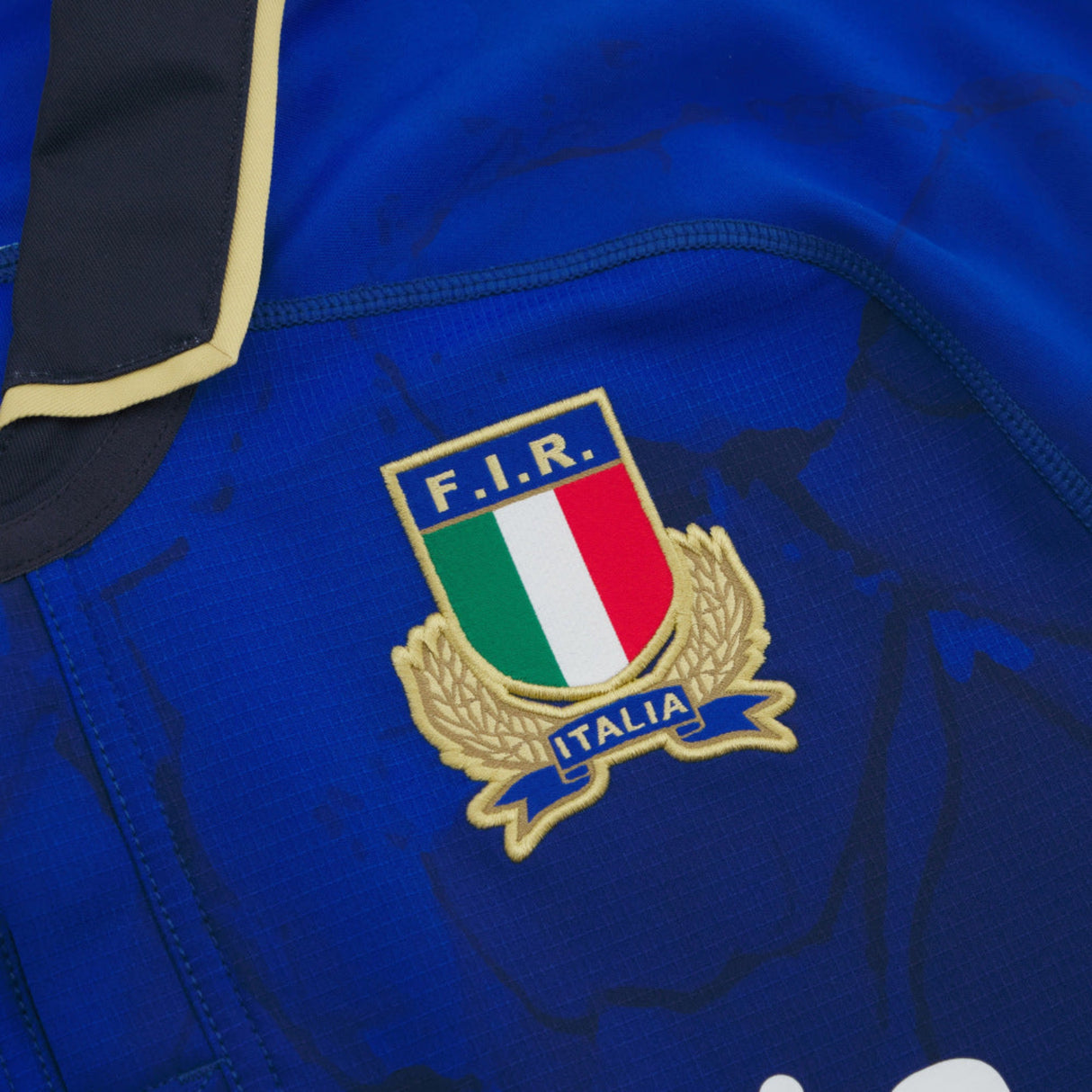 Close-up of the Italian Rugby Federation crest on the blue Italy 25/26 Authentic Home Jersey by Macron.