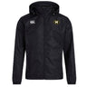 The Monarch Rugby Club VapoShield Full Zip Rain Jacket by EMB Canterbury is black with a front zipper, white Canterbury logo on the right chest, gold and black "M" emblem on the left, and features water resistant VapoShield technology.
