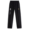 The Monarch Rugby Club Cuffed Hem Stadium Pant by EMB Canterbury features a black design with elastic waistband, cuffed hem, white logo, and a yellow "M" patch on the right leg—ideal for rugby or everyday athletic wear.