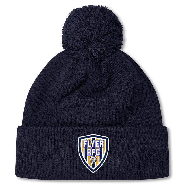 Stay warm in the EMB Canterbury Franklin County High School Rugby Pom Pom Beanie by Canterbury, featuring a navy blue knit, cozy fleece lining, and a "Flyer RFC" shield logo patch on the front cuff.