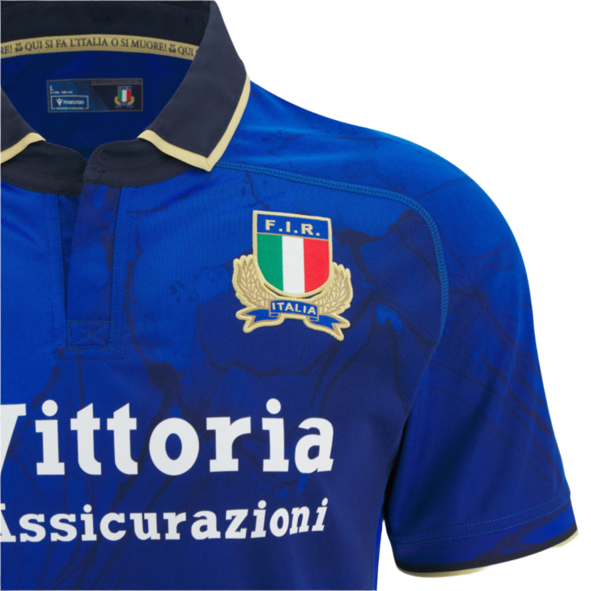 Close-up of the Italy 25/26 Replica Home Jersey by Macron, featuring the F.I.R. crest, "Vittoria Assicurazioni" sponsor logo, and detailed blue fabric from the official Italian national rugby team shirt.