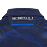 Close-up of the back of a navy Edinburgh 24/25 Replica Home Jersey by Macron, showcasing a pattern with the phrase "BUILT ON SEVEN HILLS" near the collar, encapsulating the essence of this iconic shirt.
