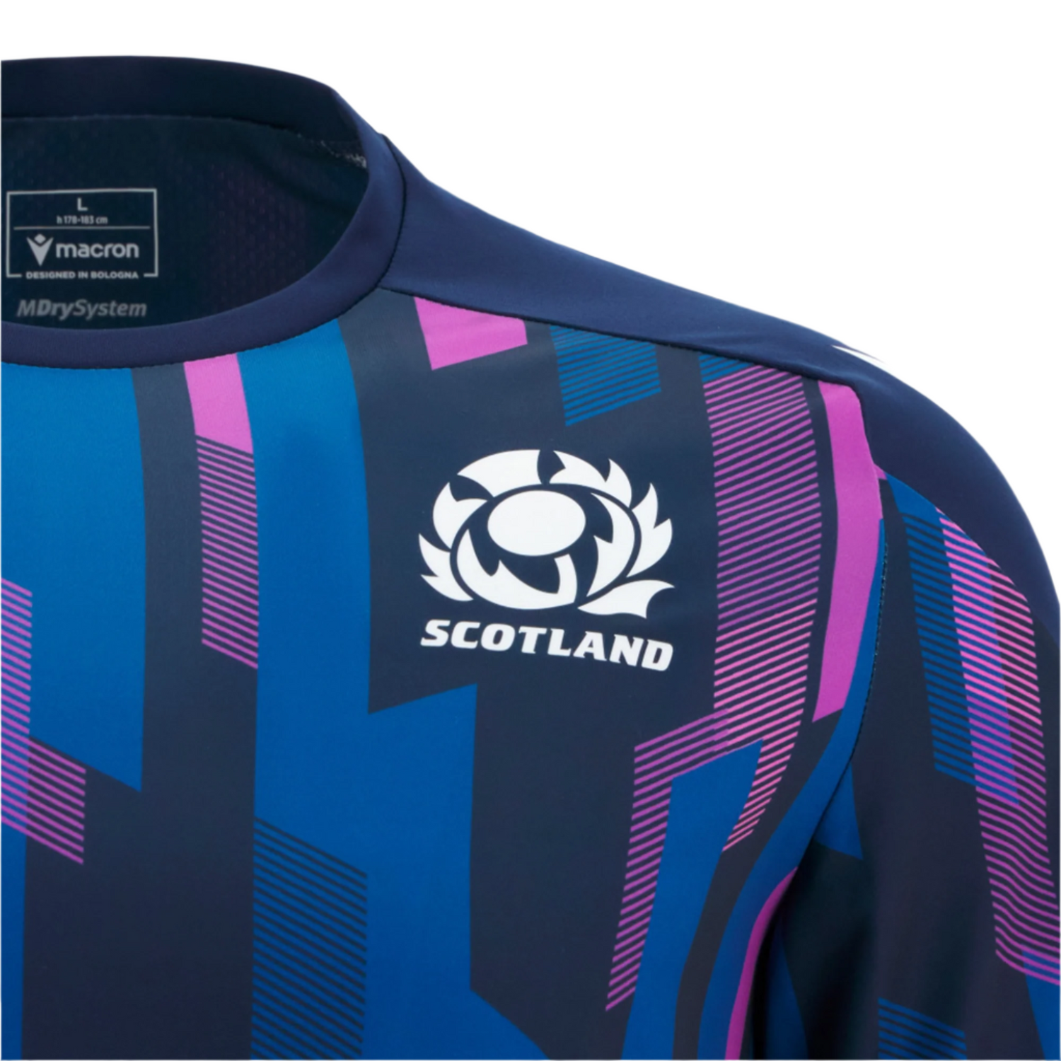 Close-up of the Scotland 25/26 Player Warm-Up Shirt by Macron, in blue and purple with a patterned design, featuring the Scotland rugby team logo and Macron branding on the shoulder and neckline.