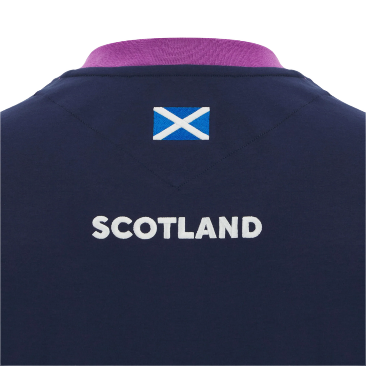 The Scotland 25/26 Player Travel T-Shirt by Macron features "SCOTLAND" in white and the Scottish flag above it on the back, all on a navy blue shirt.