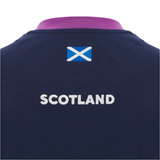 The Scotland 25/26 Player Travel T-Shirt by Macron features "SCOTLAND" in white and the Scottish flag above it on the back, all on a navy blue shirt.