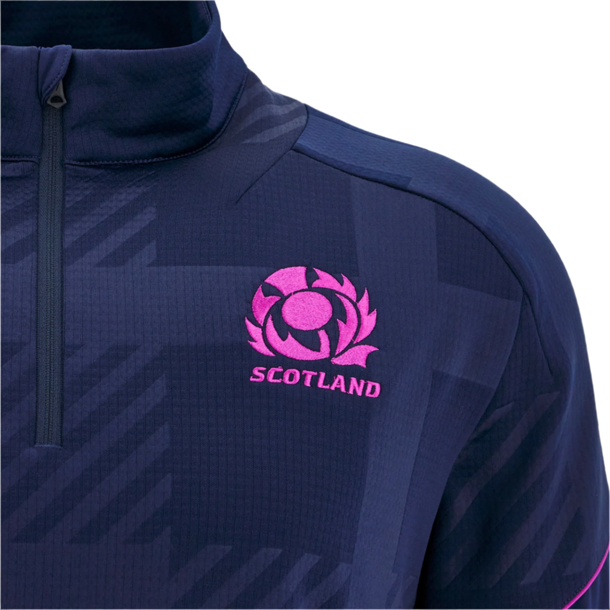 Close-up of the Scotland SRU 25/26 Player Travel 3D Fleece by Macron, featuring a pink Scotland SRU rugby logo and text on the chest.