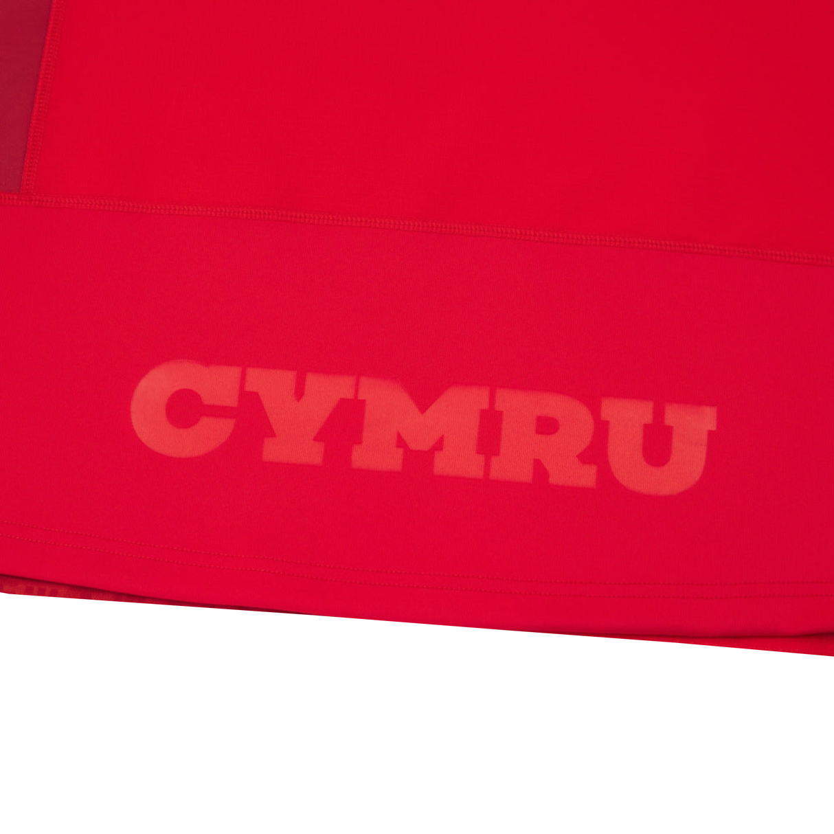 The Wales 25/26 Authentic Matchday Home Jersey by Macron features bold “CYMRU” print in a lighter red near the hem, inspired by classic Wales Rugby designs.
