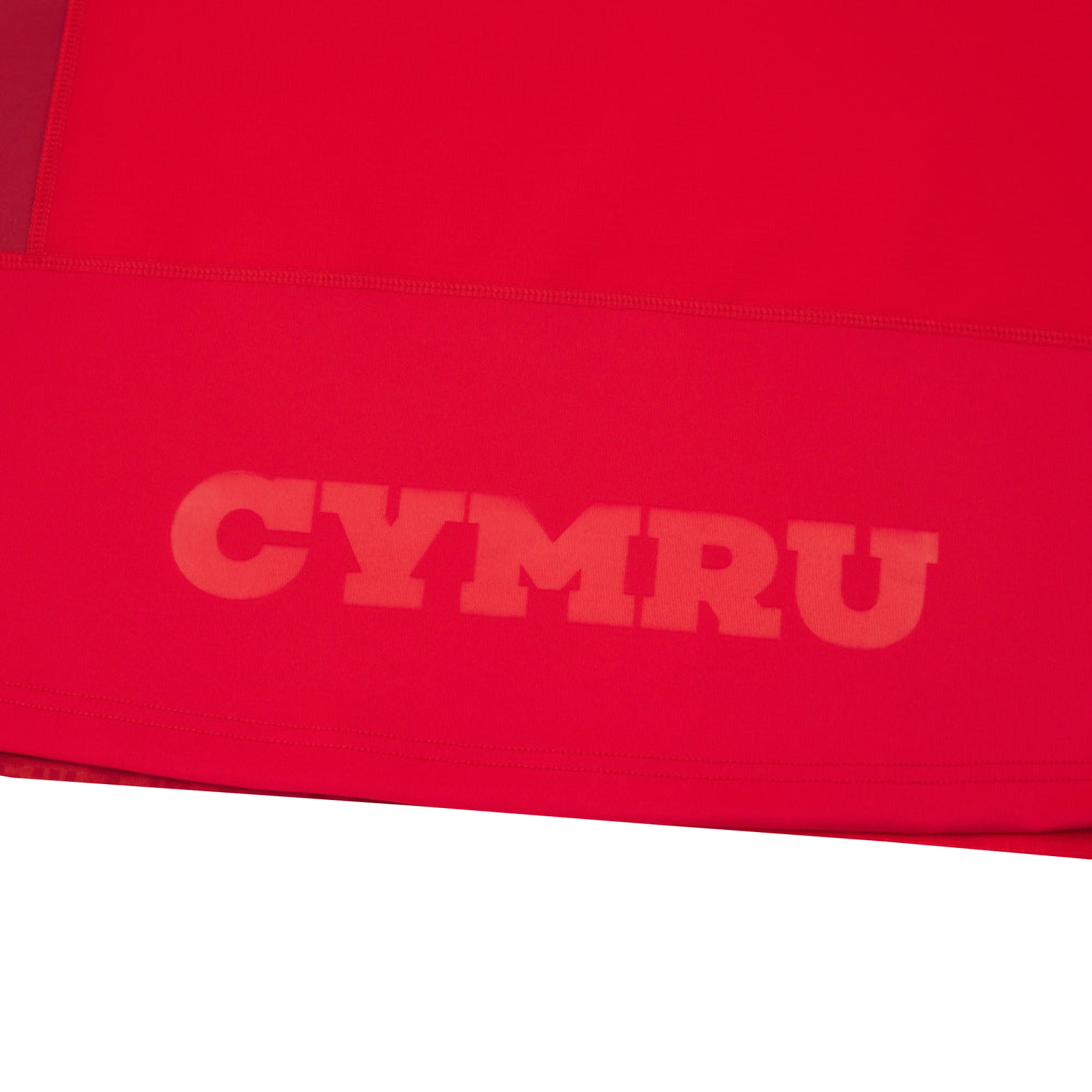 The Wales 25/26 Authentic Matchday Home Jersey by Macron features bold “CYMRU” print in a lighter red near the hem, inspired by classic Wales Rugby designs.