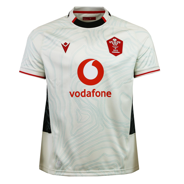 The Wales 25/26 Replica Away Jersey by Macron is a white rugby jersey with subtle topographic patterns, red trim, Vodafone sponsor logo, and the WRU emblem on the chest.