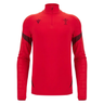 The Wales 25/26 Player 1/4 Zip Top by Macron is a red long-sleeve top featuring the Welsh Rugby Union logo and black accents on the shoulders and forearms.