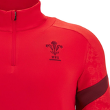 A close-up of the red Wales 25/26 Player 1/4 Zip Top by Macron, highlighting the WRU logo and chest emblem, and featuring a stylish half-zip collar.