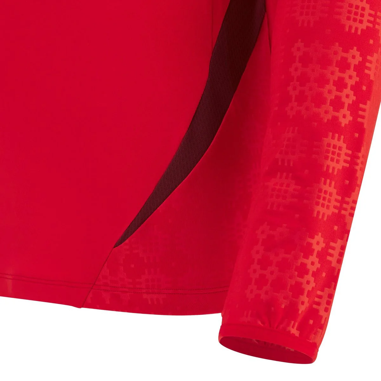 Close-up of the Wales 25/26 Player 1/4 Zip Top by Macron, showcasing geometric sleeve patterns and a dark red side panel, inspired by classic WRU style.