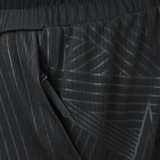 Close-up of the Wales 25/26 Basketball Shorts by Macron, featuring black textured fabric with a diagonal zipper pocket and subtle geometric line patterns, reflecting an athletic fit design typical of Macron sportswear.