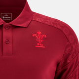 A close-up of the Wales 25/26 Player Travel Poly Polo by Macron, featuring the Welsh Rugby Union logo on the chest and patterned shoulders—a stylish classic for any fan.