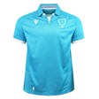 The Uruguay URU 25/26 Replica Home Jersey by Macron features light blue short sleeves, white trim, a stylized bird crest with “URU” text on the chest, and subtle sunburst patterns, all made from EcoFightex fabric.