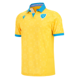 The Uruguay URU 25/26 Replica Away Jersey by Macron features yellow short sleeves, blue collar and cuffs, a blue shield logo, sunburst pattern, and is crafted from EcoFightex—echoing the classic Uruguay away style.