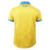 Back view of the Uruguay URU 25/26 Replica Away Jersey by Macron in yellow, featuring blue sleeve cuffs/collar, sun patterns, and "LOS TEROS" below the collar. Made from EcoFightex fabric as part of Macron's official away collection.