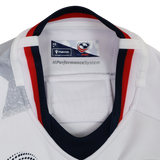 Close-up of the inside collar on the Women's USA Rugby WRWC 25 Away Bodyfit Shirt by Macron, featuring the Macron brand tag, USA Rugby logo, and "MPerformanceSystem" text for comfort and performance.