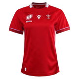 Show your support with the Women's Wales WRWC25 Replica Home Jersey by Macron—a red short-sleeve jersey with white trim, featuring the Wales Rugby logo, sponsor logos, and a subtle pattern. Perfect for any women's rugby fan.
