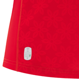 Close-up of red fabric with a subtle floral pattern and a small white eco label near the hem—part of the Women's Wales WRWC25 Replica Home Jersey by Macron.