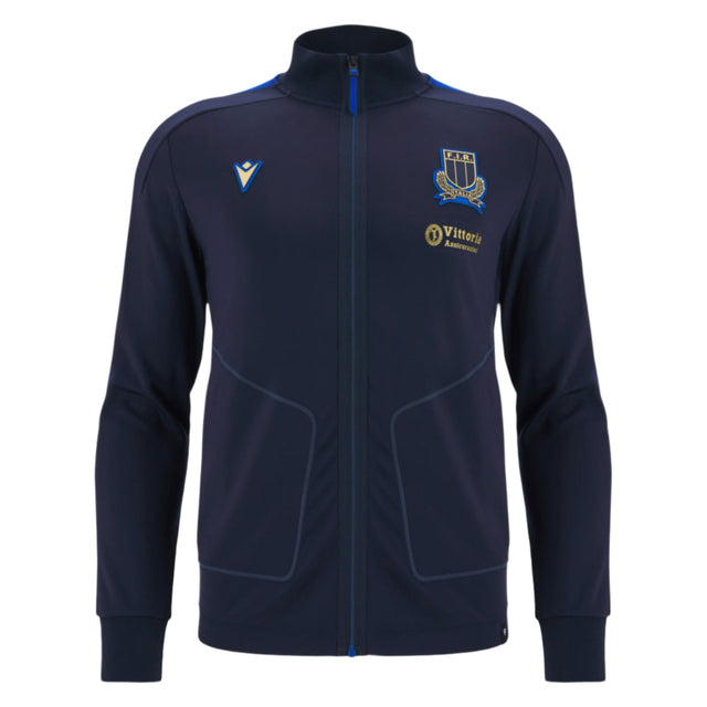 The Italy 25/26 Anthem Jacket by Macron features a navy blue zip-up design with a high collar, two side pockets, and embroidered chest logos, combining classic style and sporty elegance inspired by Italia Rugby.