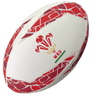 A white and red Wales Supporters Ball by Gilbert with the Welsh Rugby Union (WRU) logo, featuring three feathers and a crown.