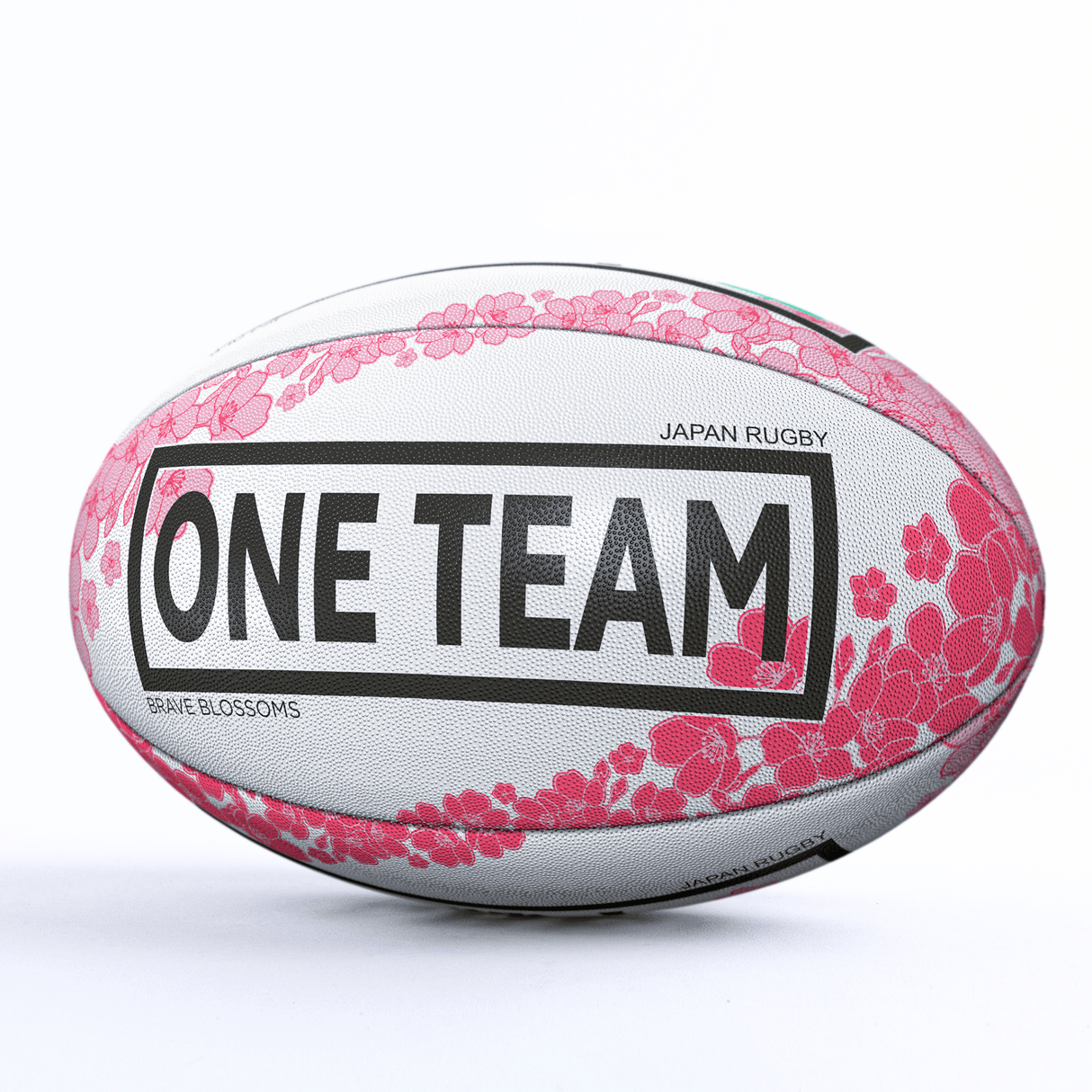 A white Japan Supporters Ball by Gilbert with pink floral designs and the words "ONE TEAM" in large black letters, alongside "Japan Rugby" and "Brave Blossoms Japan Supporters Ball" in smaller text.