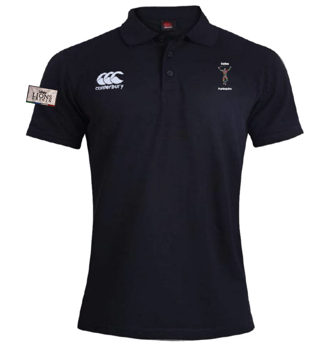 The Dallas Harlequins Lions Origin Waimak Polo by EMB Canterbury is a black short-sleeved rugby polo with a collar, white Canterbury logo, embroidered crest, "Lions" patch on the left sleeve, and is made from a cotton-polyester blend.