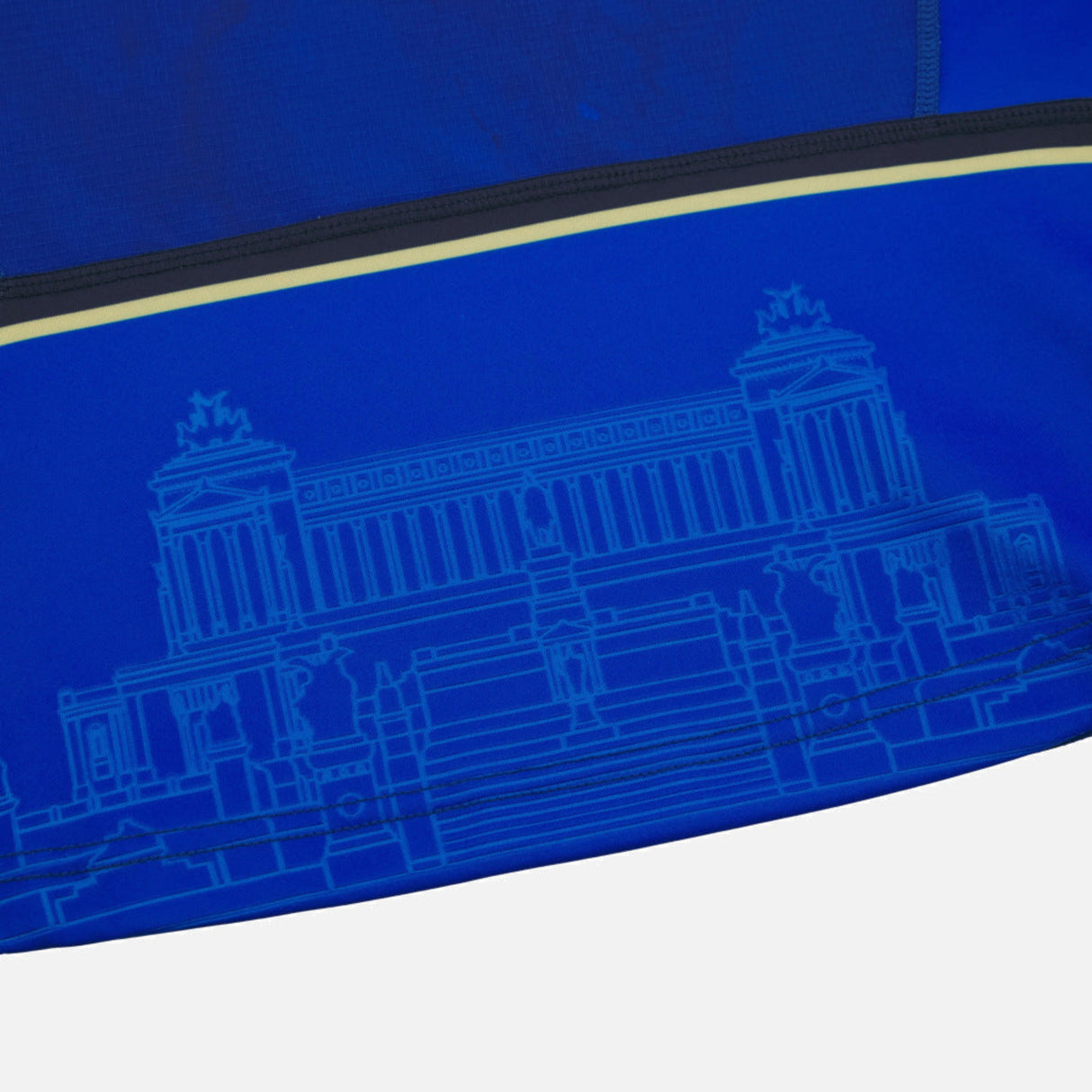 Close-up of blue fabric from the Italy 25/26 Authentic Home Jersey by Macron, with a light blue architectural line drawing of a classical building and staircase.