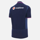 The Scotland SRU 25/26 Replica Home Jersey by Macron features navy blue with pink accents, "SCOTLAND" repeated on the lower section, and the Vodafone logo on the back—ideal for fans wanting an authentic home shirt.
