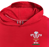 The Wales Rugby Union Pullover Fleece Hoodie by Macron, designed in a striking red, features an embroidered WRU logo on the front. The inner part of the hood proudly displays "OUR GAME THIS IS WELSH RUGBY" printed in both English and Welsh, celebrating Welsh Rugby heritage.