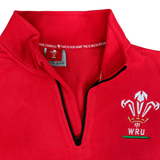 The Macron Wales Rugby Union 1/4 Zip Fleece Top is shown on a red sweatshirt.