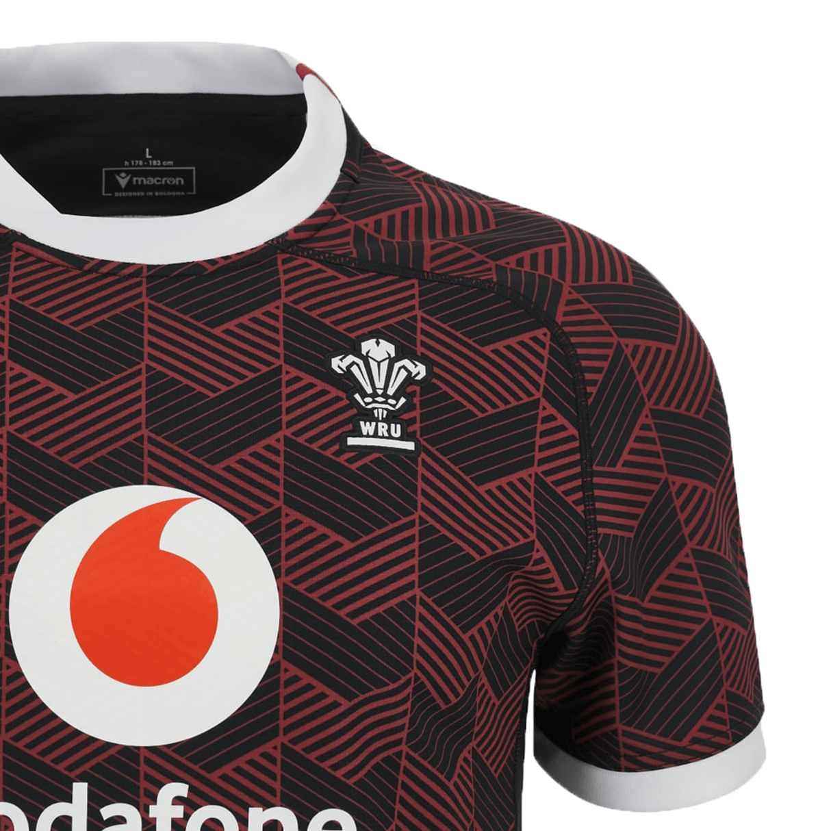 A Macron Wales Rugby Union 23/24 Training Jersey with a red and white design.