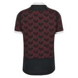 A black and red Macron Wales Rugby Union 23/24 Training Jersey with a chevron pattern.