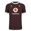 The Macron Wales Rugby Union 23/24 Training Jersey is red and black with the Macron logo on it.