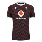 The Macron Wales Rugby Union 23/24 Training Jersey is red and black with the Macron logo on it.