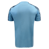 The back of a blue Manchester City soccer shirt, featuring the Macron Samoa Training Tee 23/24.