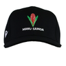 The Samoa Cap 23/24 by Macron features a black design with a red flower and green leaves logo above bold white "MANU SAMOA" text—a must-have for any Samoa Rugby fan.