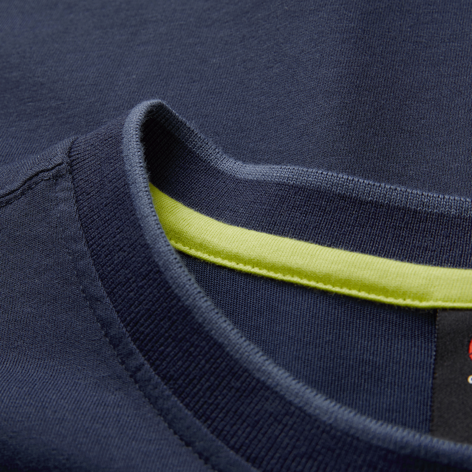 Close-up of the collar on the Ireland 26/27 Summer Tour Team Cotton T-Shirt by Canterbury in navy, showcasing a visible yellow inner trim and partial black label.