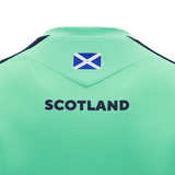 The upper back of the Scotland Training Shirt 24/25 by Macron, crafted by Macron, showcases a small Scottish flag near the collar with "Scotland" boldly printed below it. The breathable mesh fabric ensures comfort during intense training sessions.