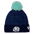 Introducing the Scotland Pom Pom Beanie 24/25 by Macron, a navy blue knit beanie adorned with a light blue pom-pom on top. It showcases an embroidered stylized thistle logo on the front and a white Macron brand emblem on the side, celebrating Scotland Rugby Union.