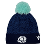 Introducing the Scotland Pom Pom Beanie 24/25 by Macron, a navy blue knit beanie adorned with a light blue pom-pom on top. It showcases an embroidered stylized thistle logo on the front and a white Macron brand emblem on the side, celebrating Scotland Rugby Union.