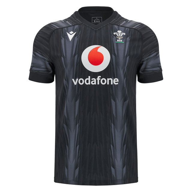 The Wales 24/25 Training Jersey by Macron, in black, features a subtle design alongside the Vodafone logo and the Wales Rugby emblem, capturing the essence of a true Wales Training Jersey.