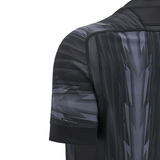 Close-up of the Wales 24/25 Training Jersey by Macron, featuring a black and gray color scheme with geometric patterns and short sleeves.