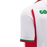The Wales 24/25 6 Nations Replica Away Jersey by Macron showcases green and red accents against a white backdrop, with subtle lettering visible on the back. Perfect for fans, this jersey beautifully blends style with sport.
