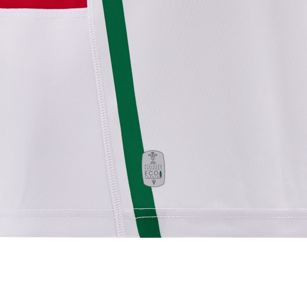 A close-up of a white fabric featuring vertical green and red stripes, reminiscent of the classic Wales 24/25 6 Nations Replica Away Jersey by Macron. There is an eco-friendly label near the bottom center, emphasizing sustainable craftsmanship.